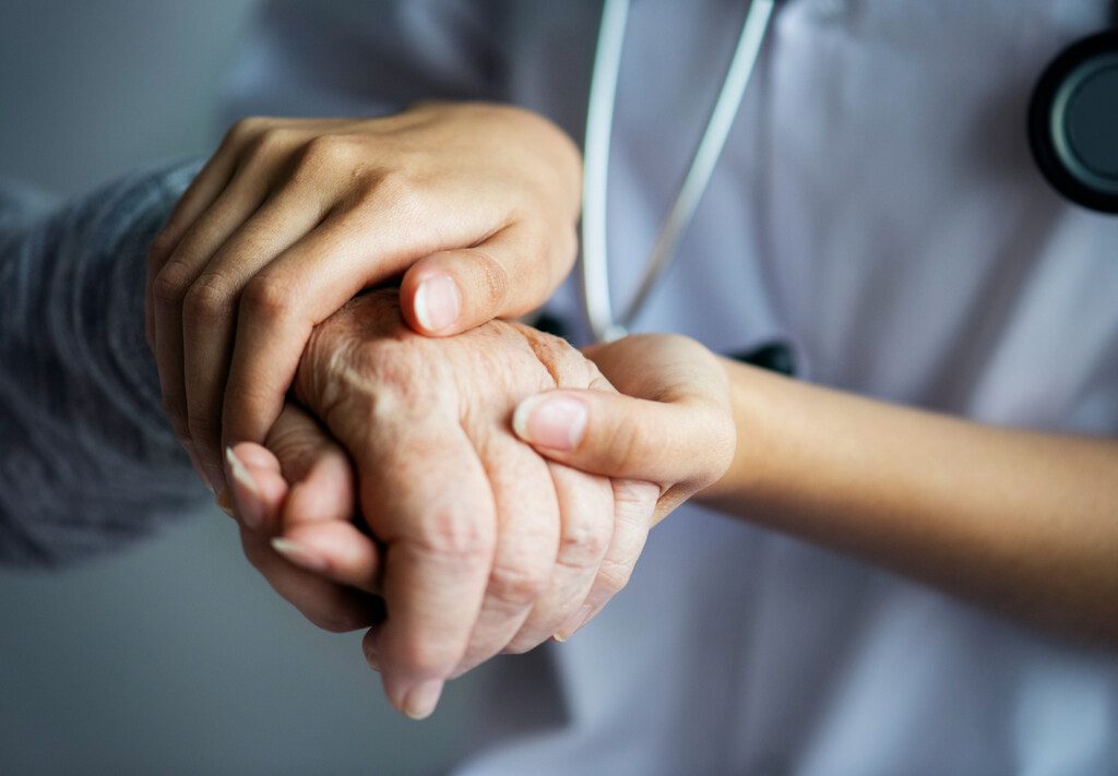 médica segurando mão de paciente